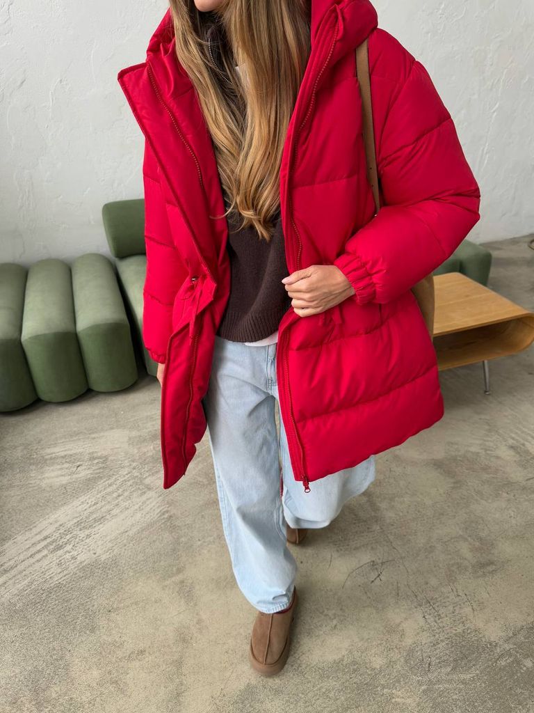 Червоний подовжений зимовий пуховик на кулісці  Червоний подовжений зимовий пуховик на кулісці