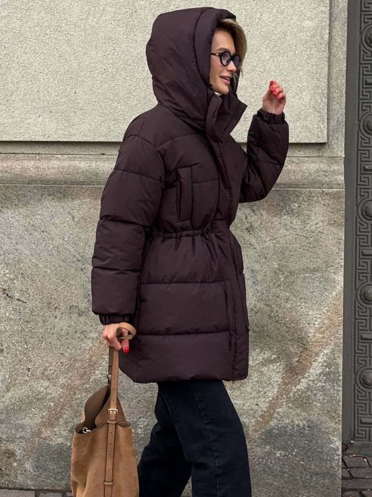 Шоколадний подовжений зимовий пуховик на кулісці