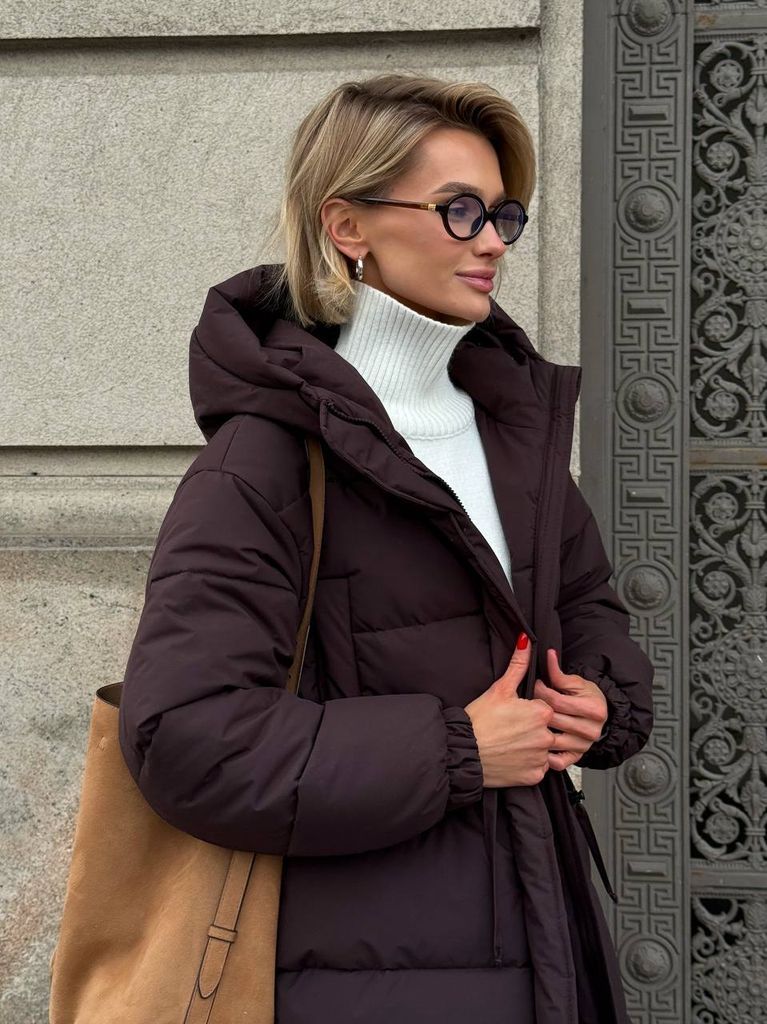 Шоколадний подовжений зимовий пуховик на кулісці