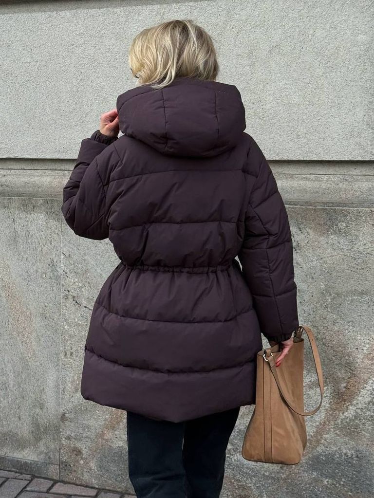 Шоколадний подовжений зимовий пуховик на кулісці